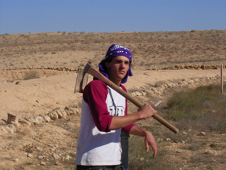 This high school student carries a hoe in a school project to study and restore the ancient agricultural terrace areas of Nitzana.