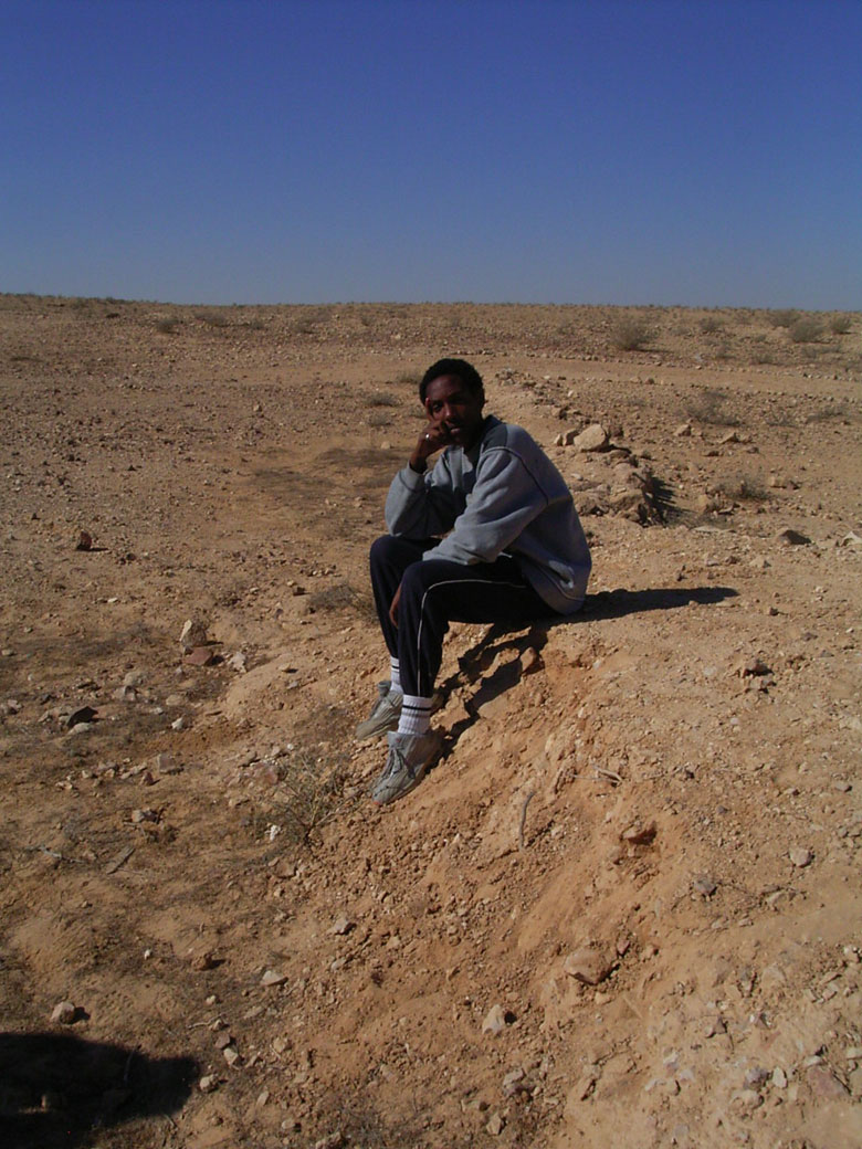 Nitzana farm maintenance project with students includes overturning of the soil, getting rid of bushes and brush, cleaning up the area, and planting.  This student takes a break near an ancient terrace.