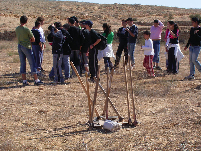 Nitzana farm maintenance project with students includes overturning of the soil, getting rid of bushes and brush, cleaning up the area, and planting.  The farming tools are waiting for the students.