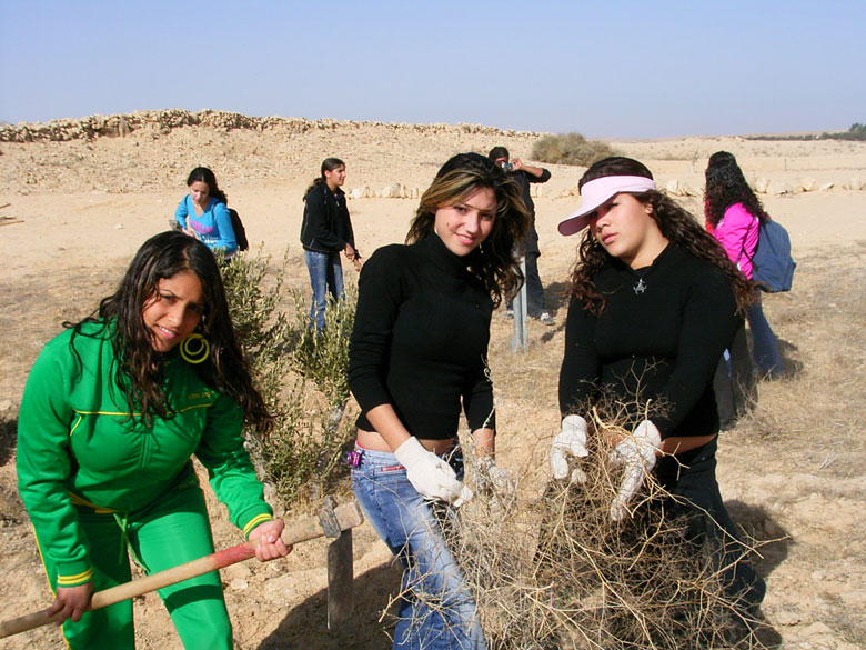 These high school students learn in the field of the ancient agricultural terraces at Nitzana while having fun, where the ground is being prepared to plant new trees. High school students and staff help to landscape the trees, take care of them, and prune them.