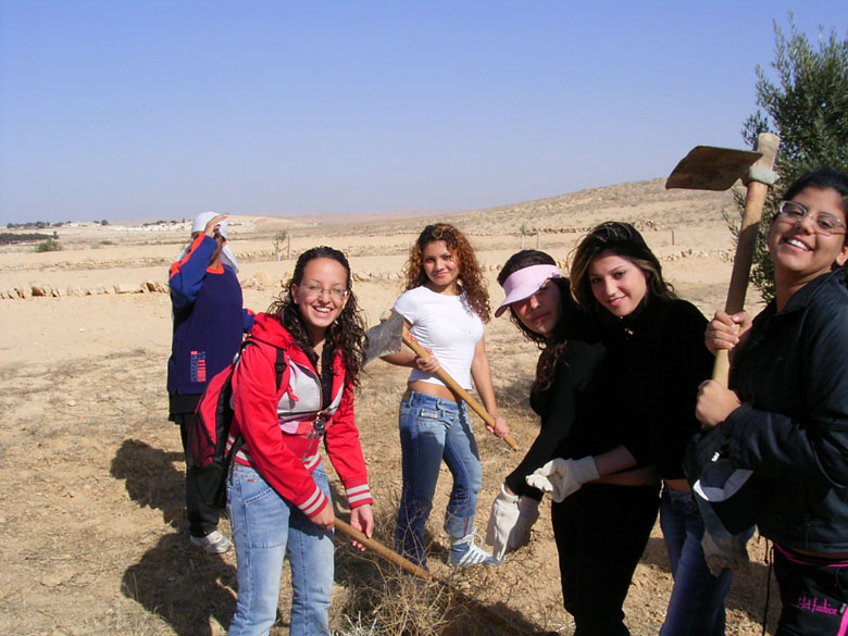 These high school students learn in the field of the ancient agricultural terraces at Nitzana while having fun, where the ground is being prepared to plant new trees. High school students and staff help to landscape the trees, take care of them, and prune them.