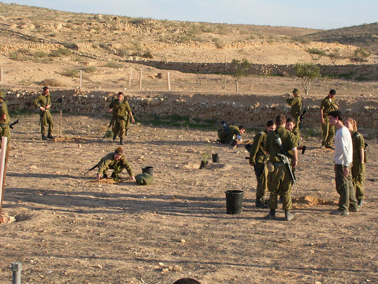 Israeli IDF soldiers serving in the desert on duty in the Negev, help to rejuvenate the Negev ancient agricultural installations, joining staff and high school students at Nitzana.  These soldiers plant new trees in the desert.