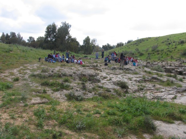 Field lecture at Ofaqim. Located 20 kilometers northwest of Beer Sheva, this is the Merchavim School. Students here are shown measuring and surveying an ancient agricultural site from the Byzantine Period, which consists of ruins of a farm house and several water cisterns and an ancient agricultural terrace.