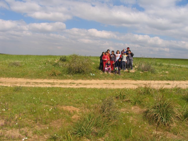 Class of students on top of the ruin at Ofaqim. Located 20 kilometers northwest of Beer Sheva, this is the Merchavim School. Students here are shown measuring and surveying an ancient agricultural site from the Byzantine Period, which consists of ruins of a farm house and several water cisterns and an ancient agricultural terrace.