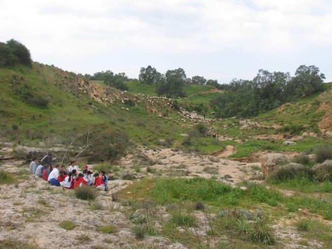 Field lecture at Ofaqim. Located 20 kilometers northwest of Beer Sheva, this is the Merchavim School. Students here are shown measuring and surveying an ancient agricultural site from the Byzantine Period, which consists of ruins of a farm house and several water cisterns and an ancient agricultural terrace.