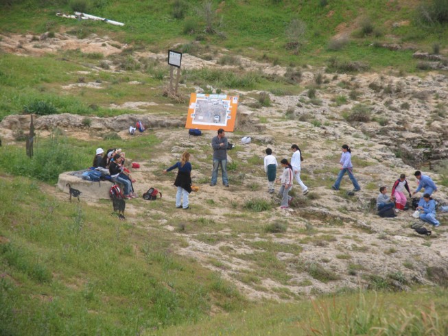 Surveying around the water cistern at Ofaqim. Located 20 kilometers northwest of Beer Sheva, this is the Merchavim School. Students here are shown measuring and surveying an ancient agricultural site from the Byzantine Period, which consists of ruins of a farm house and several water cisterns and an ancient agricultural terrace.